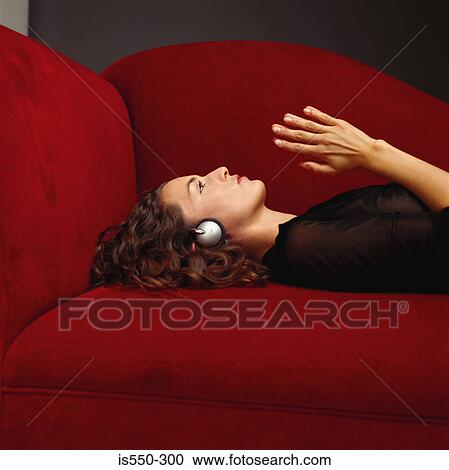 Woman wearing headphones on sofa View Large Photo Image Stock Image - Woman wearing headphones on sofa. Fotosearch