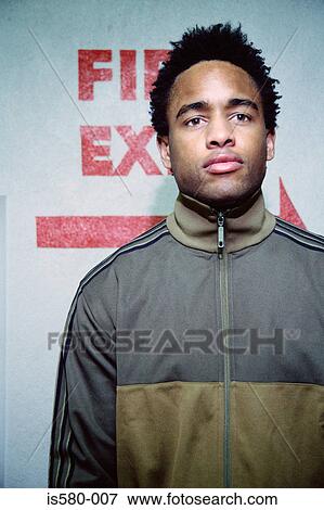 Young man at fire exit sign View Large Photo Image Stock Photo - Young man at fire exit sign. Fotosearch