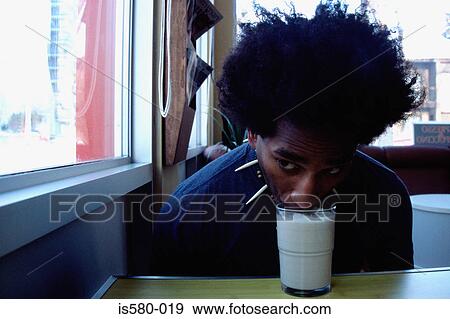 Young man drinks without hands View Large Photo Image Stock Photo - Young man drinks without hands. Fotosearch
