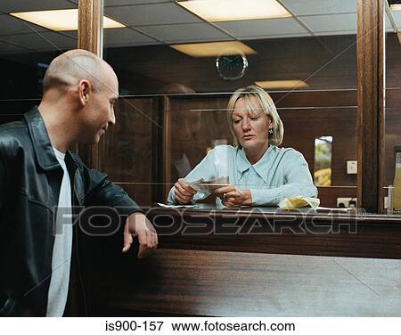 Stock Photo - Betting shop worker counting money for customer. Fotosearch