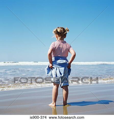 Picture - Girl standing by the sea. Fotosearch