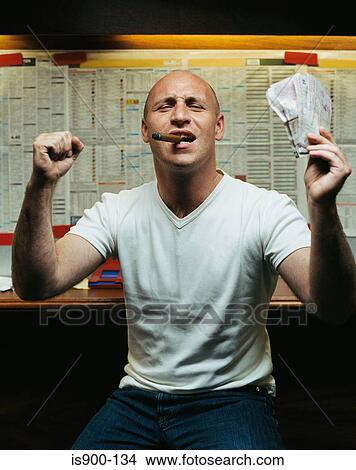 Picture - Man celebrating win at betting shop. Fotosearch