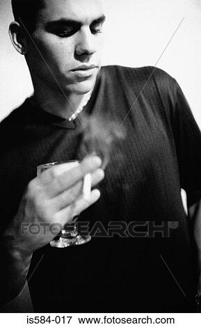Man holding a cigarette and wine glass View Large Photo Image Stock Photo - Man holding a cigarette and wine glass. Fotosearch