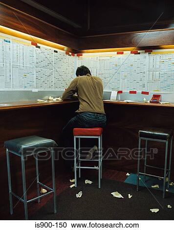 Stock Image - Man in a betting shop. Fotosearch