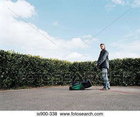 Stock Photo - Man mowing a concrete lawn. Fotosearch