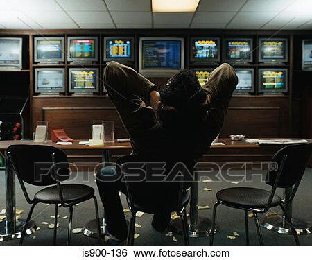 Stock Photograph - Man sitting in a betting shop. Fotosearch