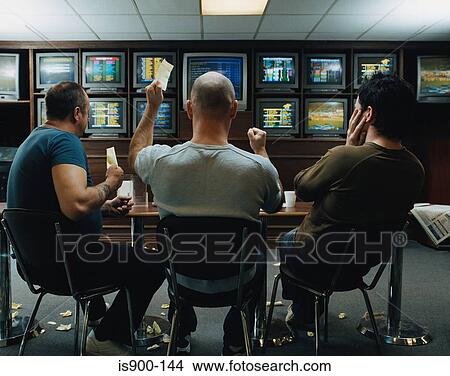 Picture - Three men in a betting shop. Fotosearch