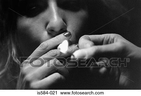 Woman lighting a cigarette View Large Photo Image Stock Image - Woman lighting a cigarette. Fotosearch