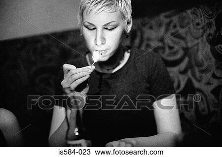 Stock Image - Woman lighting a cigarette. Fotosearch