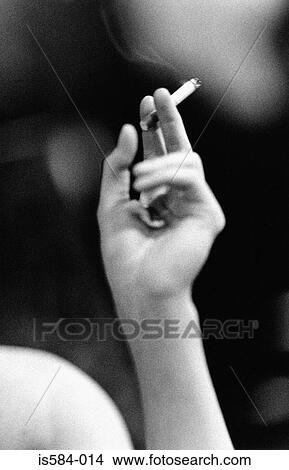 Woman smoking a cigarette View Large Photo Image Picture - Woman smoking a cigarette. Fotosearch