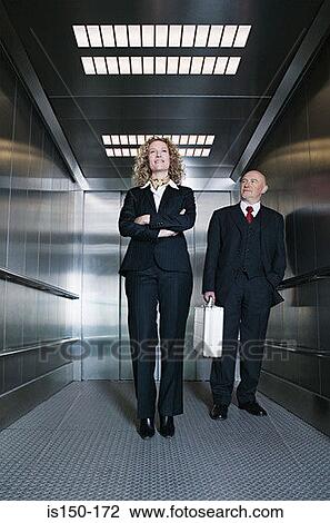 Stock Image - Businessman and businesswoman in a lift. Fotosearch