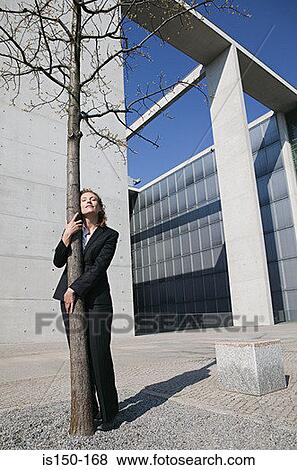 Stock Photo - Businesswoman hugging a tree. Fotosearch
