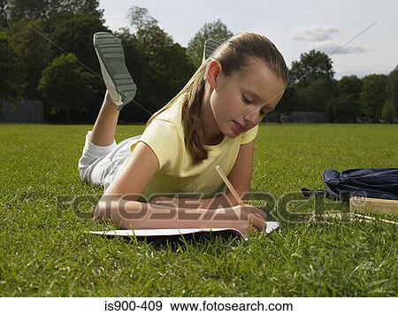 Stock Photo - Girl doing homework in a park. Fotosearch