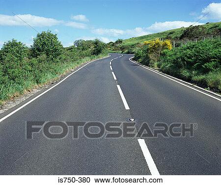 Stock Image - Road through the countryside. Fotosearch