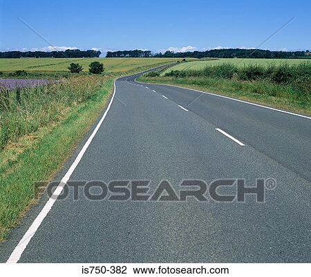Stock Image - Road through the countryside. Fotosearch