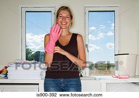 Stock Image - Woman putting on rubber glove. Fotosearch