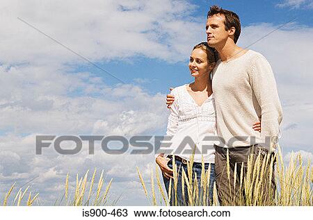 Stock Image - Couple in a marram grass field. Fotosearch