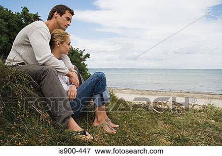 Stock Photo - Couple relaxing near the coast. Fotosearch
