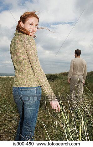 Woman standing in a field of marram grass View Large Photo Image Stock Image - Woman standing in a field of marram grass. Fotosearch