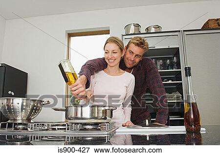 Stock Photo - Young couple cooking together. Fotosearch