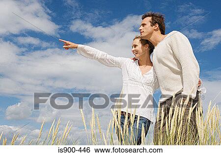 Stock Photograph - Young couple in marram grass field. Fotosearch