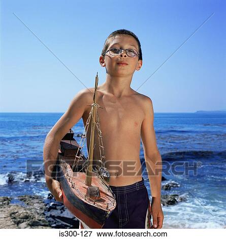 Boy holding model boat View Large Photo Image Stock Photo - Boy holding model boat. Fotosearch