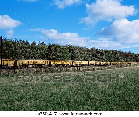 Stock Photo - Cargo train passing field. Fotosearch
