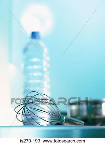 Stock Image - Whisk by bottle of water. Fotosearch