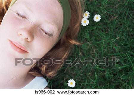 Face of girl lying on grass View Large Photo Image Stock Image - Face of girl lying on grass. Fotosearch