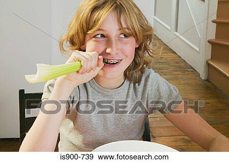 Girl biting a celery stick View Large Photo Image Stock Photo - Girl biting a celery stick. Fotosearch