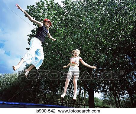 Stock Image - Two girls jumping on trampoline. Fotosearch