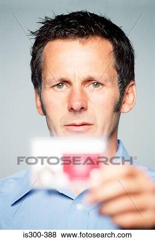 Man holding an identity card View Large Photo Image Stock Photo - Man holding an identity card. Fotosearch