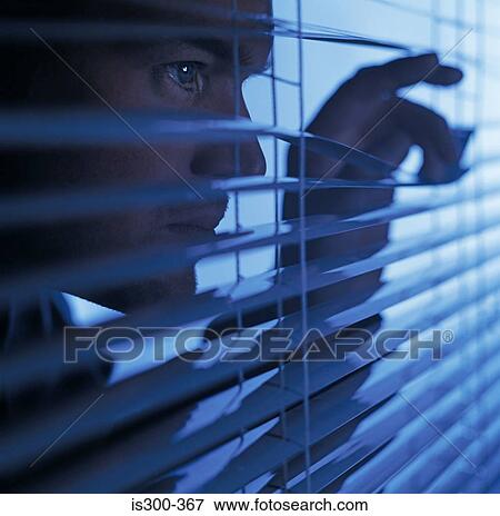 Stock Photo - Man looking through blinds. Fotosearch