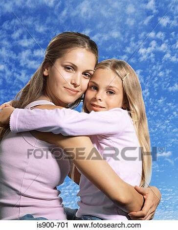 Stock Image - Mother hugging daughter. Fotosearch