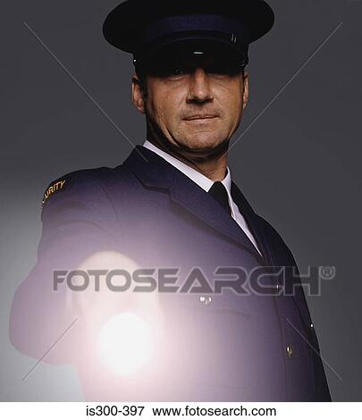 Stock Photo - Security guard shining a torch. Fotosearch