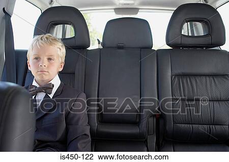 Stock Image - Boy in a car wearing a dinner jacket. Fotosearch