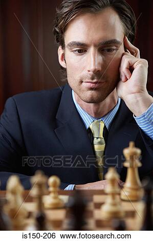 Stock Photograph - Businessman playing chess. Fotosearch