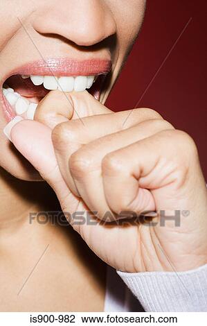 Stock Image - Woman biting her knuckle. Fotosearch