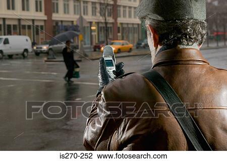 Man in street with cellphone View Large Photo Image Stock Image - Man in street with cellphone. Fotosearch