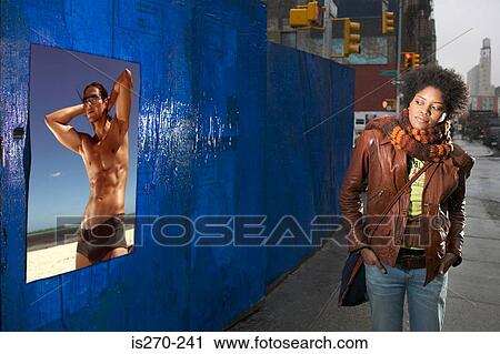 Woman looking at poster of bare chested man View Large Photo Image Stock Image - Woman looking at poster of bare chested man. Fotosearch