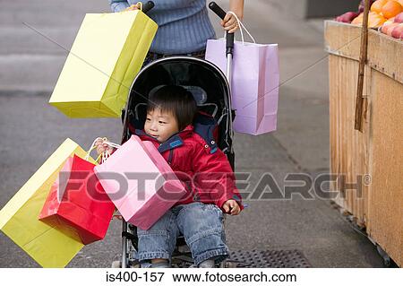 Boy in a pushchair with shopping bags View Large Photo Image Stock Photo - Boy in a pushchair with shopping bags. Fotosearch