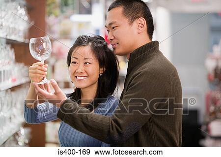 Stock Photo - Couple shopping for wine glasses. Fotosearch