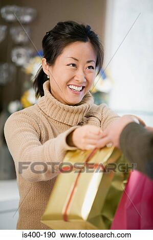 Woman handing over bags View Large Photo Image Stock Image - Woman handing over bags. Fotosearch