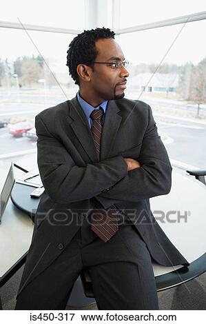 Stock Photo - Businessman sitting on desk. Fotosearch