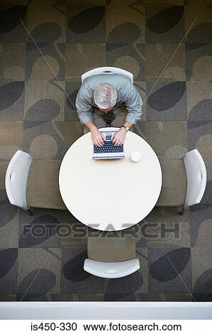Stock Image - Businessman working in cafeteria. Fotosearch