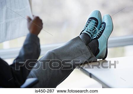 Man putting feet up on desk View Large Photo Image Stock Photo - Man putting feet up on desk. Fotosearch