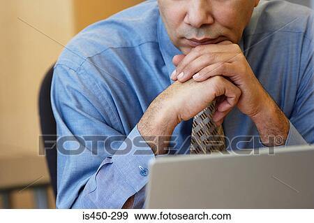 Stock Photo - Man sitting by laptop. Fotosearch