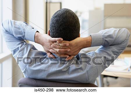 Stock Photo - Office worker with hands behind head. Fotosearch