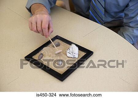 Picture - Office worker with zen garden. Fotosearch