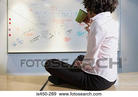 Woman sitting on desk drinking coffee View Large Photo Image Stock Photo - Woman sitting on desk drinking coffee. Fotosearch